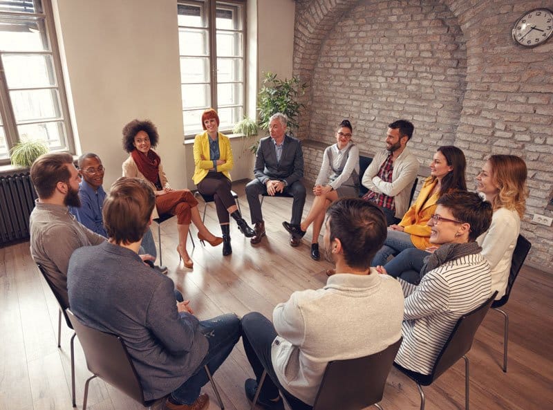 Business people talking at group meeting in circle