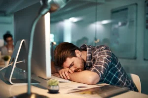 The Importance of Sleep - man sleeping at work - sleep deprivation