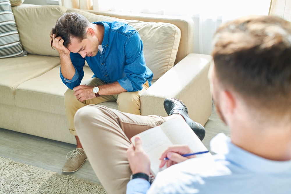 Man speaking to man in group therapy