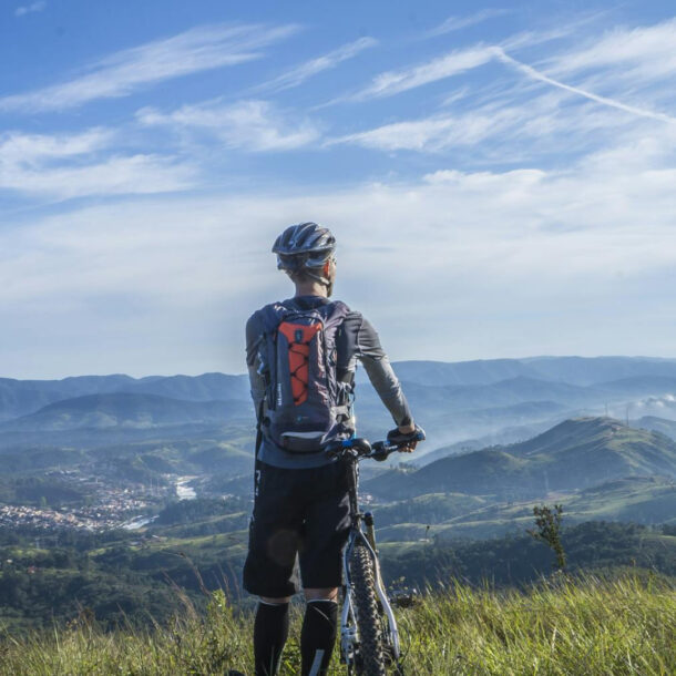 male taking a break from riding a bike - overlooking a beautiful view