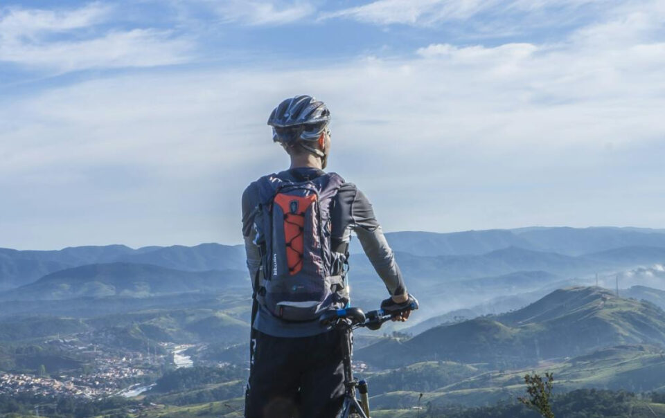 male taking a break from riding a bike - overlooking a beautiful view