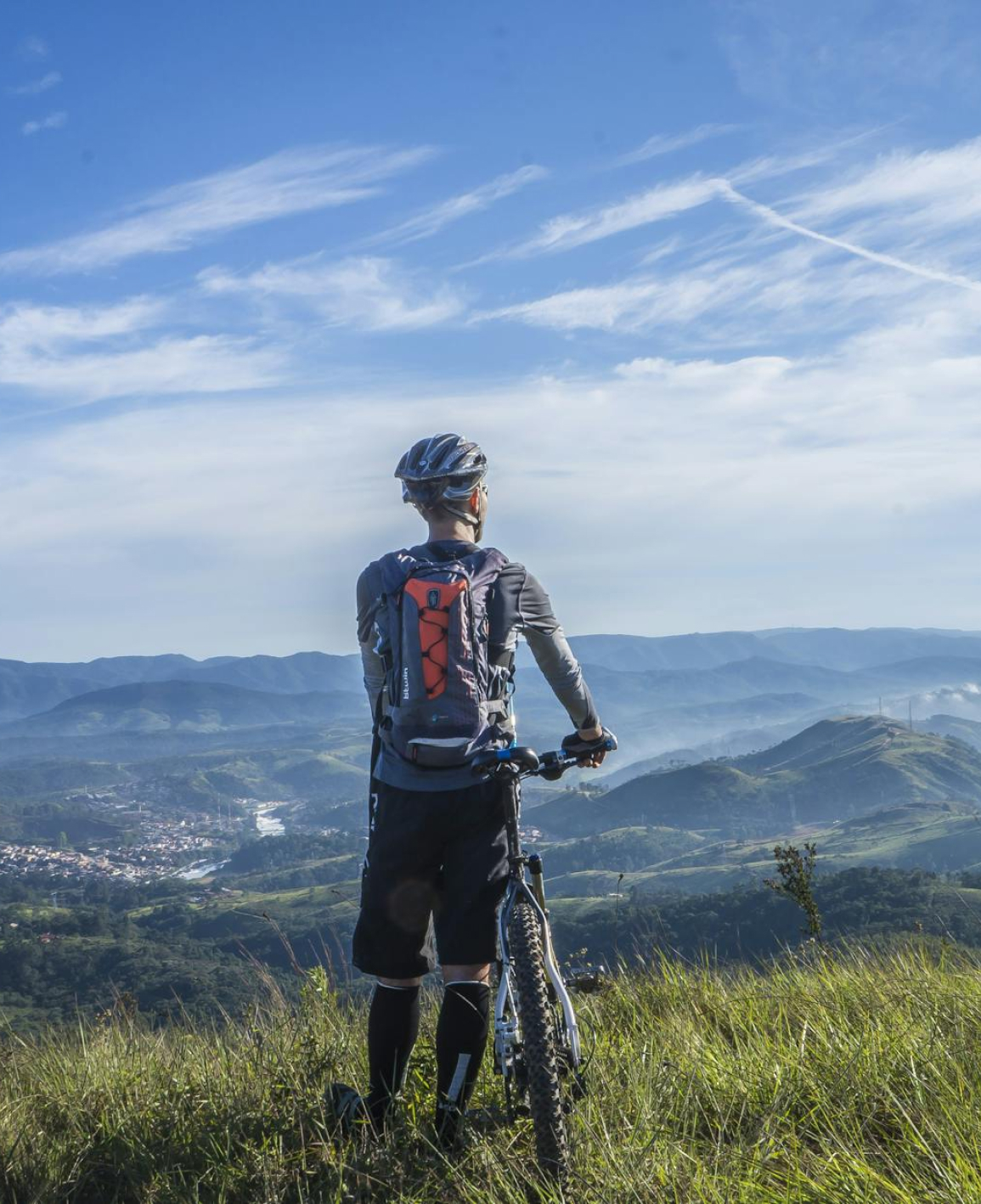 male taking a break from riding a bike - overlooking a beautiful view