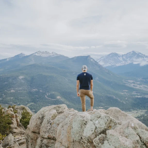 Residential vs. Outpatient Treatment - man standing on a rock with mountain view