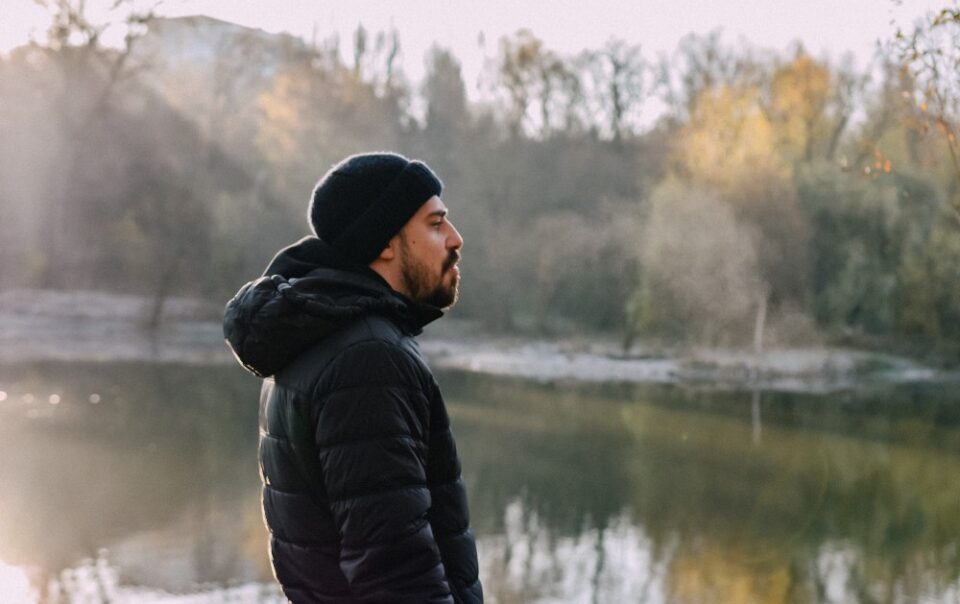 man looking forlorn near lake