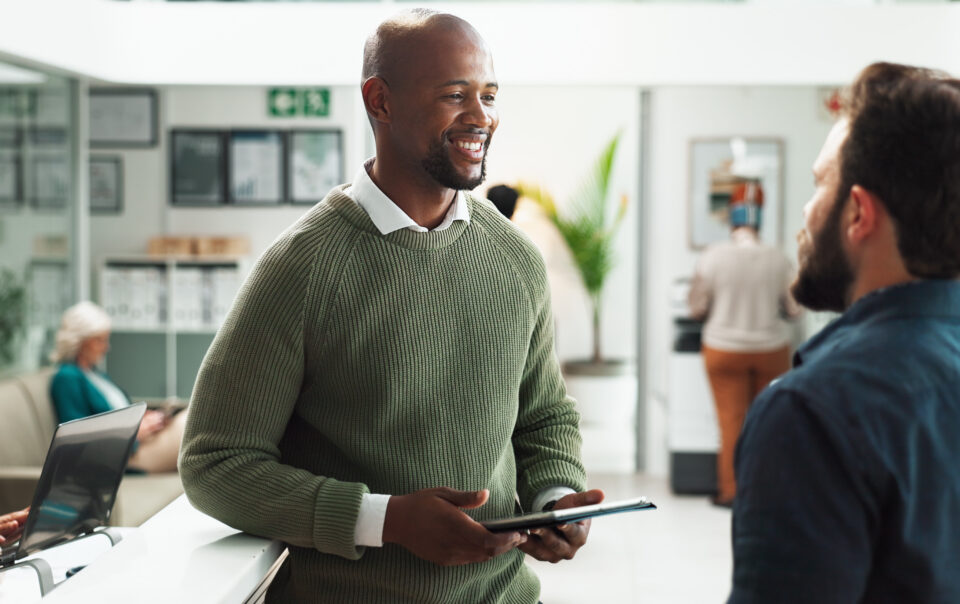 Two men in an office talking about how to pay for rehab.